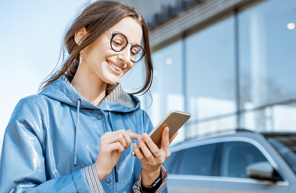 niña mirando su teléfono y sonriendo